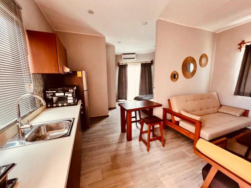 eine Küche und ein Wohnzimmer mit einem Sofa und einem Tisch in der Unterkunft Hotel Manglar Suites in Mahahual