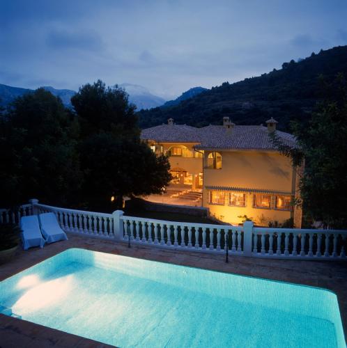 a swimming pool in front of a house at Hotel Villa Lehmi in Tárbena