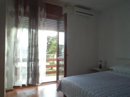 a bedroom with a bed and a large window at Apartment Nella in Molat