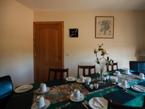 einen Esstisch mit einem blauen Tischtuch und Teller in der Unterkunft Shenavallie Farm in Benderloch