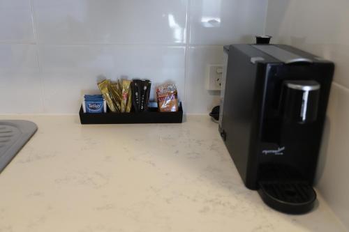 a black refrigerator in a room with a counter at Kallangur Motel in Kallangur