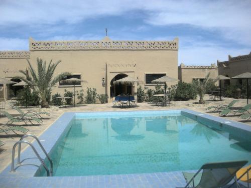 a large swimming pool in front of a building at Les Portes Du Desert in Merzouga