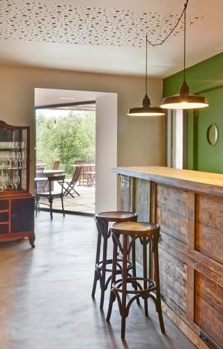 a kitchen with two stools and a bar with chairs at Hotel Restaurant Lotus Priorat in Falset