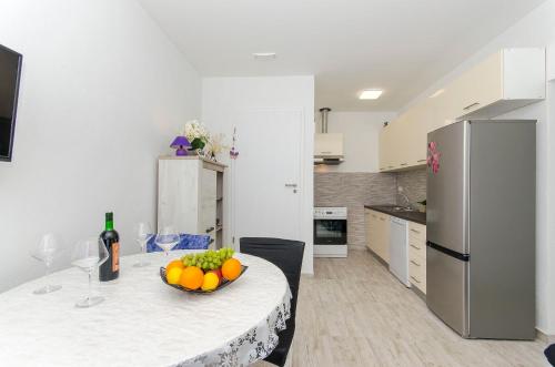 a kitchen with a table with a bowl of fruit on it at Apartment Paradise in Postira
