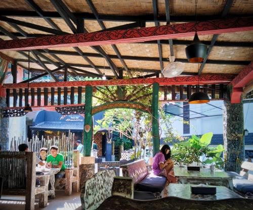 a woman sitting at a table in a restaurant at Jungle Inn Bukit lawang in Bukit Lawang