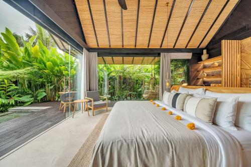 a bedroom with a large bed and a large window at Desa Hay Canggu in Canggu