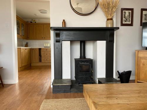 a living room with a black stove in a room at Auverne in Bude