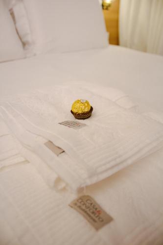 a white bed with a gold object on it at True América apart-hotel in Campos dos Goytacazes