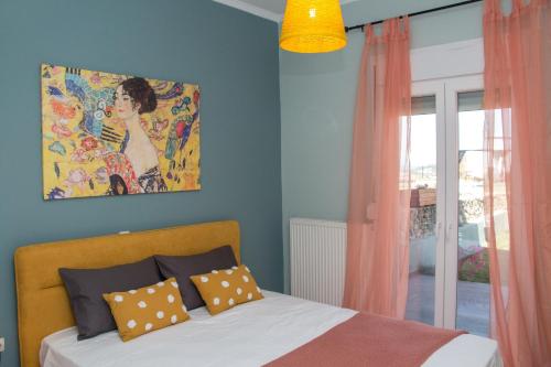 a bedroom with a bed and a painting on the wall at Heaven Hill Villas ground floor in Gouvia