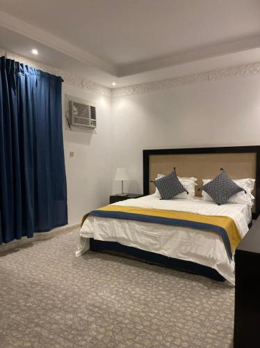 Schlafzimmer mit einem großen Bett und blauen Vorhängen in der Unterkunft Armada Star in Riad