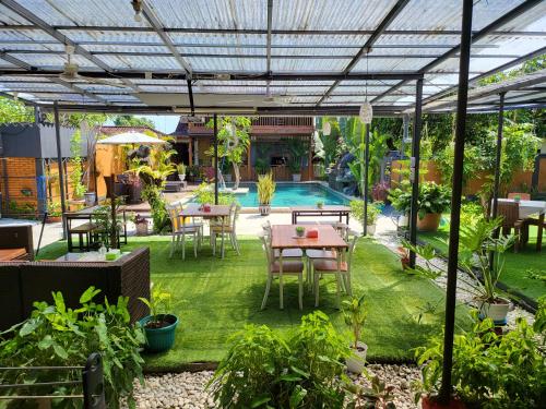 a patio with a table and chairs and a pool at Dewi Sri Guesthouse in Mataram
