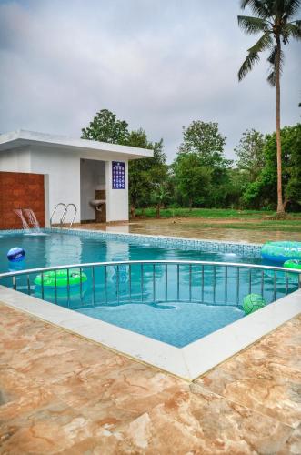 a swimming pool in front of a house at Nadhiyoram River Retreat in Cochin