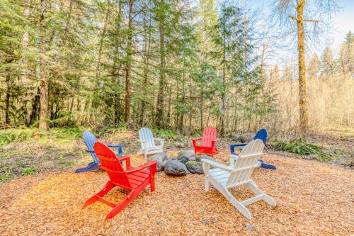 four colorful chairs sitting around a fire pit at Riverside Sanctuary in Rhododendron