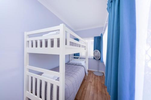 a white bunk bed in a room with a ladder at Forster Holiday Village in Forster