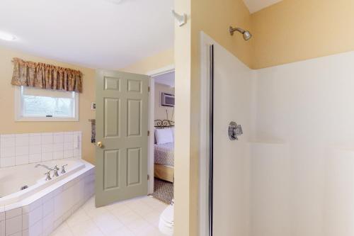 a bathroom with a tub and a toilet and a sink at Beach Plum Townhouse in Ogunquit