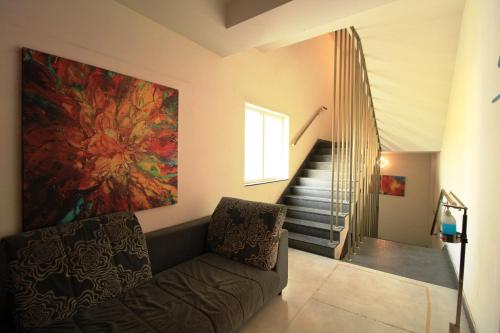 a living room with a couch and a staircase at Arunaa Inn Airport Hotel,Chennai in Chennai