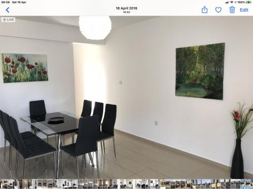 a dining room with a table and chairs and a painting at Villa Nissi Beach 28 in Ayia Napa