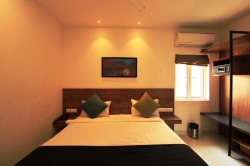 a bedroom with a large bed in a room at Arunaa Inn Airport Hotel,Chennai in Chennai