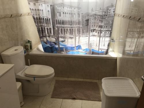a bathroom with a toilet and a window with a view at Villa Nissi Beach 28 in Ayia Napa