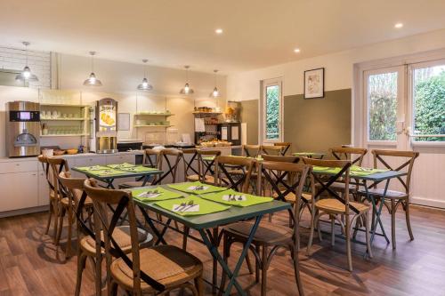 une salle à manger avec tables et chaises et une cuisine dans l'établissement Sure Hotel by Best Western Plaisir, à Plaisir