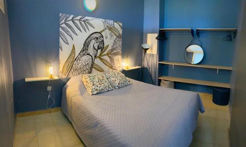 - une chambre bleue avec un lit et un oreiller pour les oiseaux dans l'établissement Appartements vue mer, à Saint-Florent