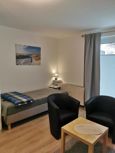 um quarto com uma cama, uma cadeira e uma mesa em Ferienwohnung Mammut 1 em Salzgitter