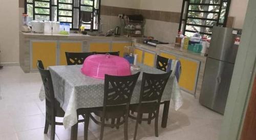 een keuken met een tafel met een roze deksel erop bij Dusun Rimbun Agro Farmstay 2 in Kuala Kerai