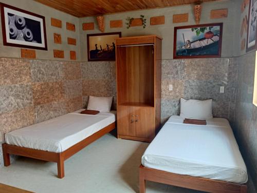 een kamer met twee bedden en een kast erin bij Terra Cotta Homestay in Hội An