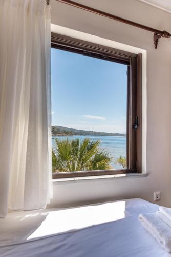 a bedroom with a window with a view of the ocean at Alkis House by AegianKazarte in Kapótidhes