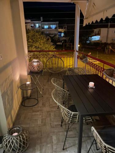a black table and chairs on a balcony at night at Apartament in Thessaloniki in Paliókastron