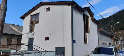 a white house with a car parked in front of it at ELEANA in Borjomi