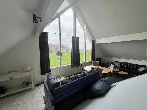 sala de estar con sofá azul y mesa en Groot Antink, en Groenlo