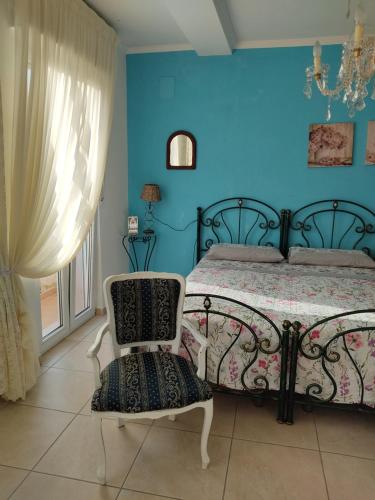 1 dormitorio con paredes azules, 1 cama y 1 silla en Villa Lucia Anna, en Scalo dei Saraceni Manfredonia
