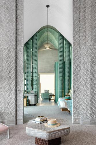 a living room with green columns and a table at JOALI BEING in Raa Atoll