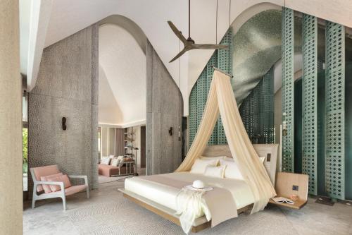 um quarto com uma cama com uma rede de descanso em JOALI BEING em Raa Atoll