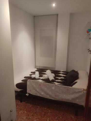 - une chambre dotée d'un lit avec des draps noirs et blancs dans l'établissement APARTAMENTO Casa Corazones de Teruel, à Teruel