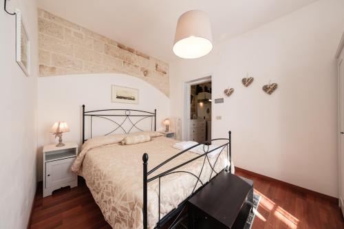 a bedroom with a bed and a brick wall at Casa Chiasso Cacace in Monopoli