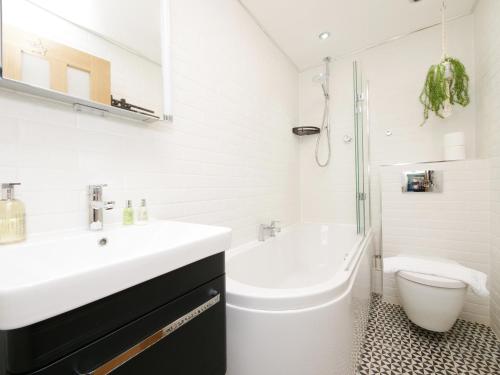 a white bathroom with a sink and a toilet at Forget-Me-Not House 3 Bed home in York Centre - Free Parking in York