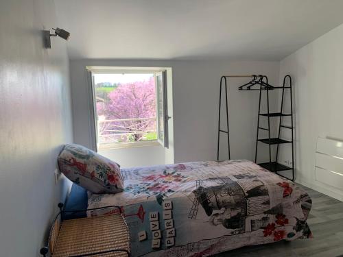 a bedroom with a bed and a window at La maison d’Eloi in Montignac-Charente