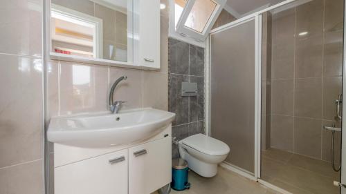 a bathroom with a sink and a toilet and a shower at Blue - 4 Bedroom Holiday Villa in Hisarönü in Oludeniz