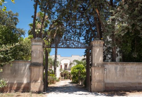 una puerta abierta a una casa con una valla en Palazzo Francesco Grassi, en Aradeo