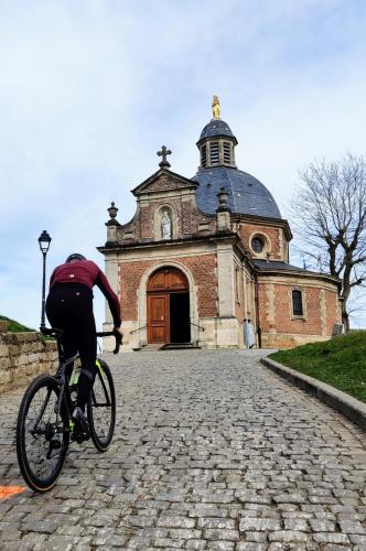 a man riding a bike in front of a church at Flandrien Hotel in Brakel