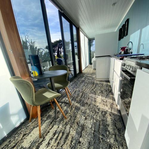 a kitchen with a table and chairs and windows at Ross Beach TOP10 Holiday Park in Ross