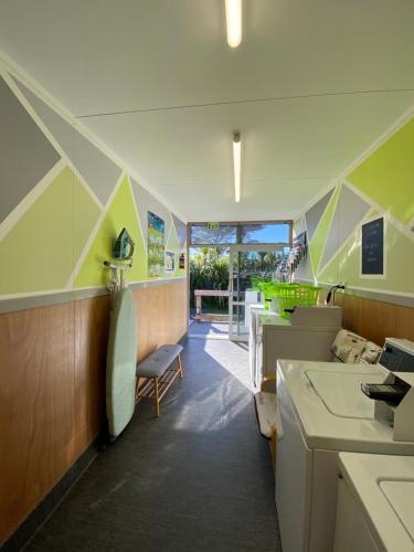 a room with green and white walls and a kitchen at Ross Beach TOP10 Holiday Park in Ross