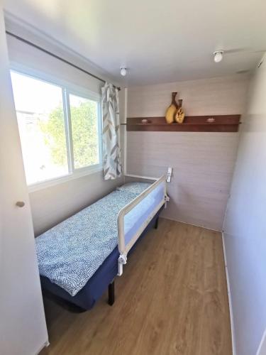 a small bedroom with a bed and a window at Casa Azul-Tiny house with fantastic view, big outdoor space and pool in Silves