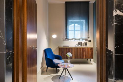 a room with a blue chair and a table at Byssus Suites in Syracuse