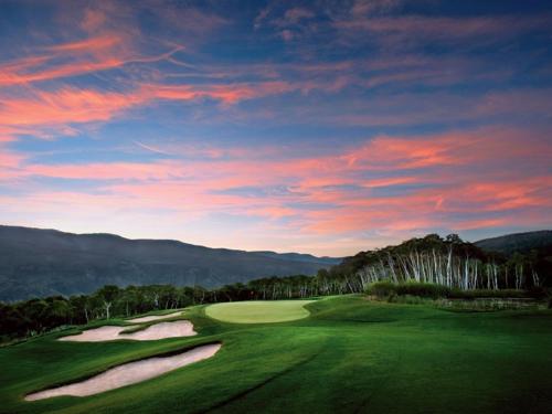 a view of a golf course with a sunset at St. James Place in Beaver Creek