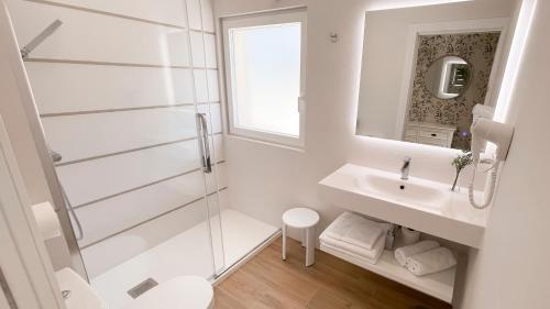 a white bathroom with a shower and a sink at Luxury Río in Santillana del Mar