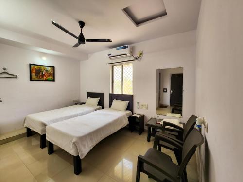 a bedroom with two beds and a table and chairs at Shivani Inn Hotel & Banquet in Seonī