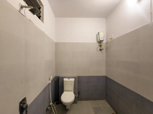 a bathroom with a toilet and a phone on the wall at Shivani Inn Hotel & Banquet in Seonī
